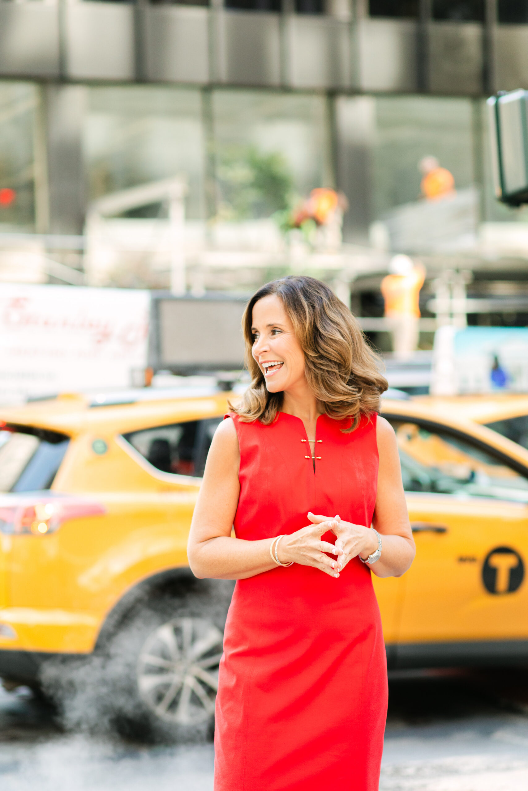 a girl in a red dress in front of a taxi 