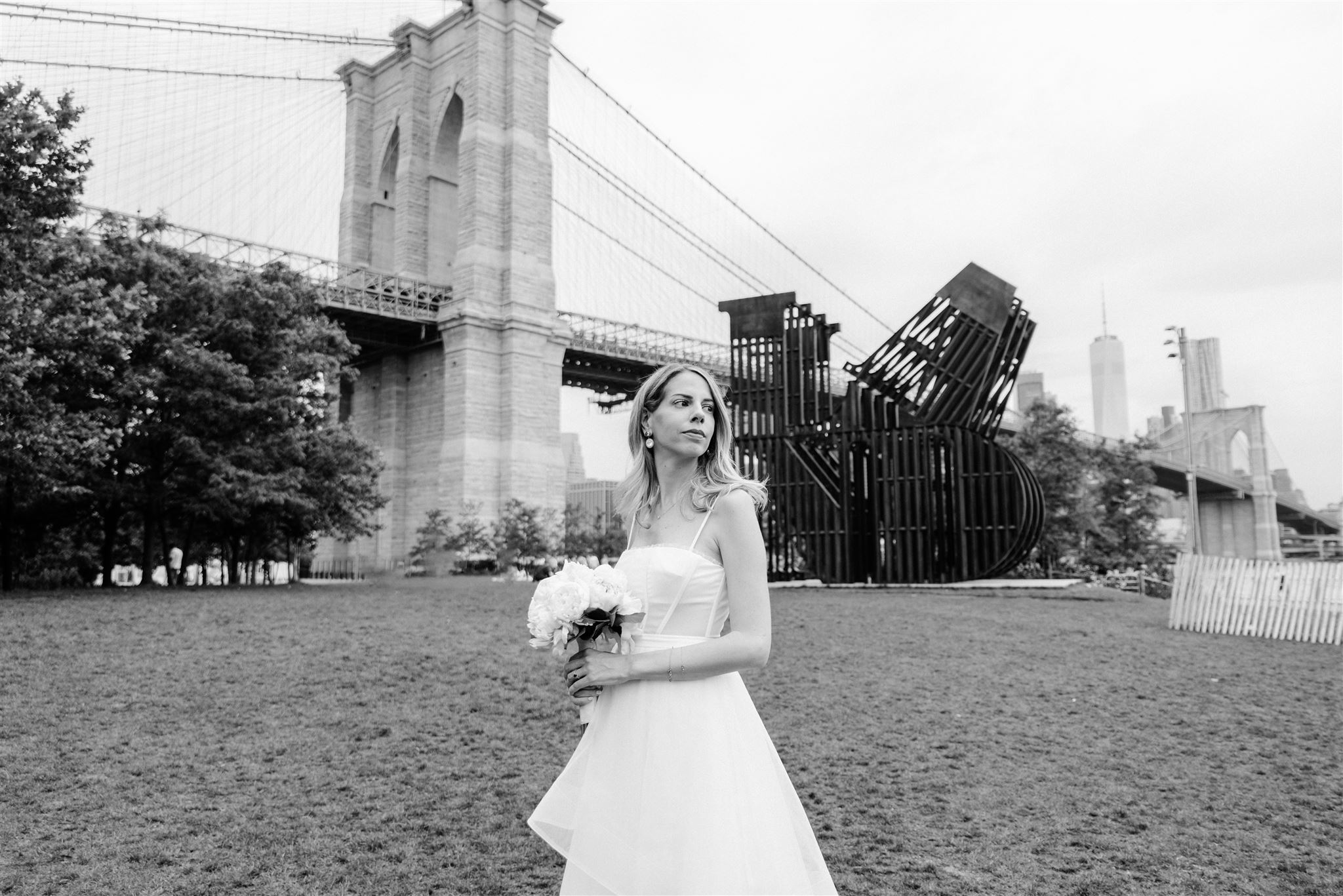 bride in her wedding dress in front of a bridge in DUMBO after her NYC city hall elopement