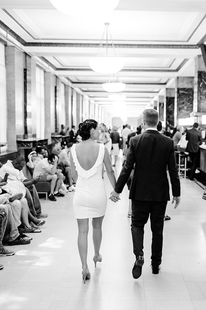 man and a woman walking hand in hand from their nyc city hall elopement