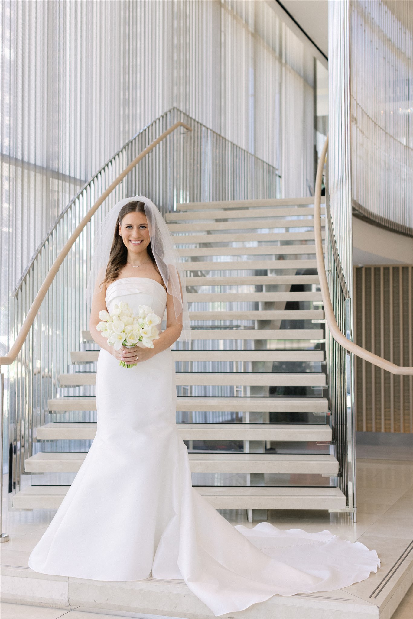 bride holding her bouquet in front of the stairs at Hall Arts Hotel