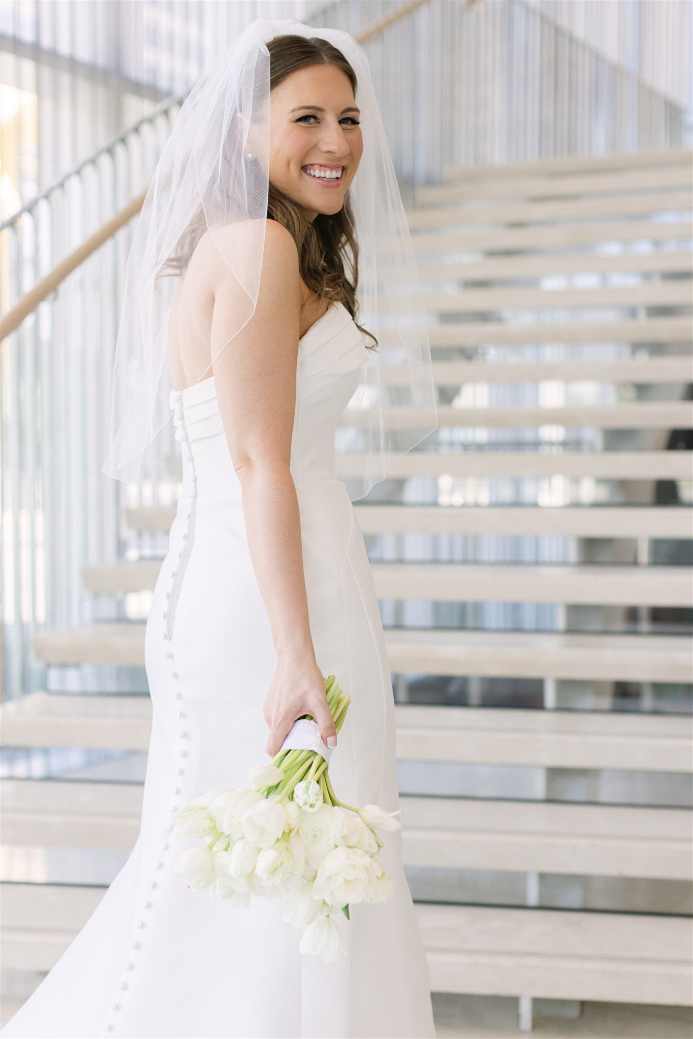 bride holding her bouquet in front of the stairs at Hall Arts Hotel