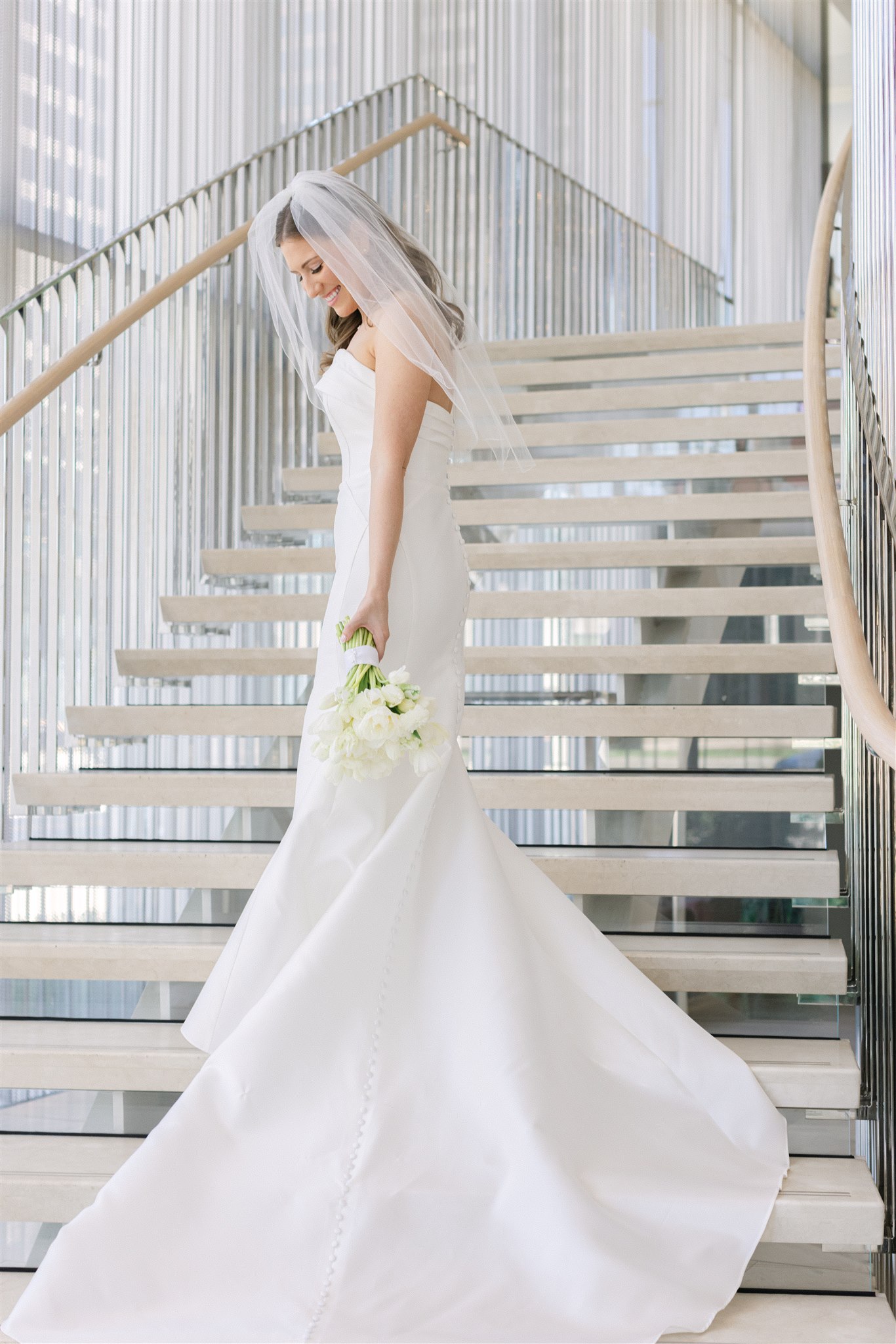 bride holding her bouquet in front of the stairs at Hall Arts Hotel