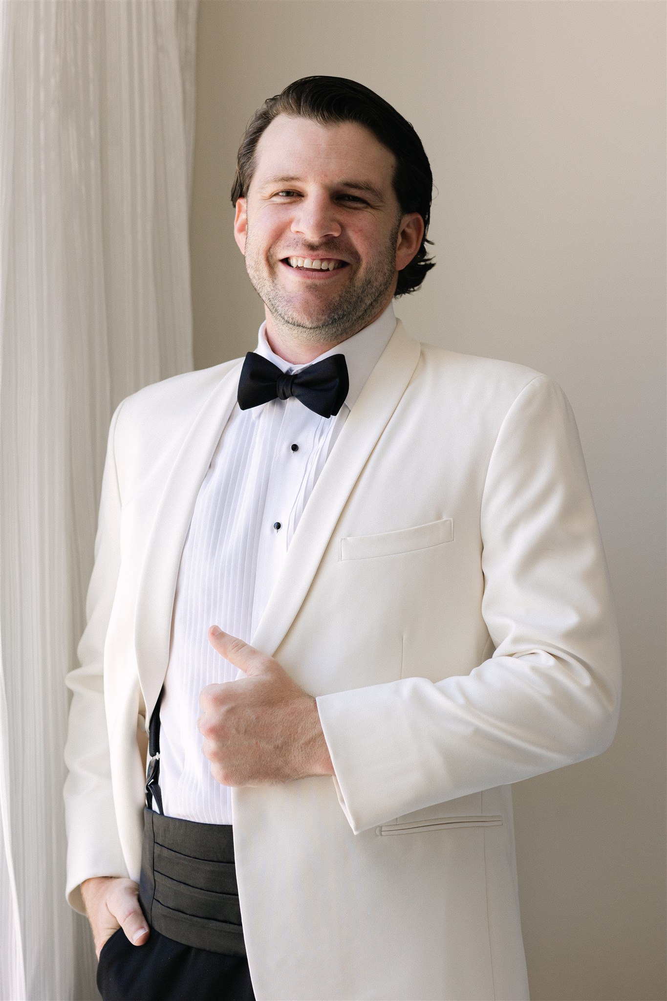 groom wearing a white tuxedo jacket