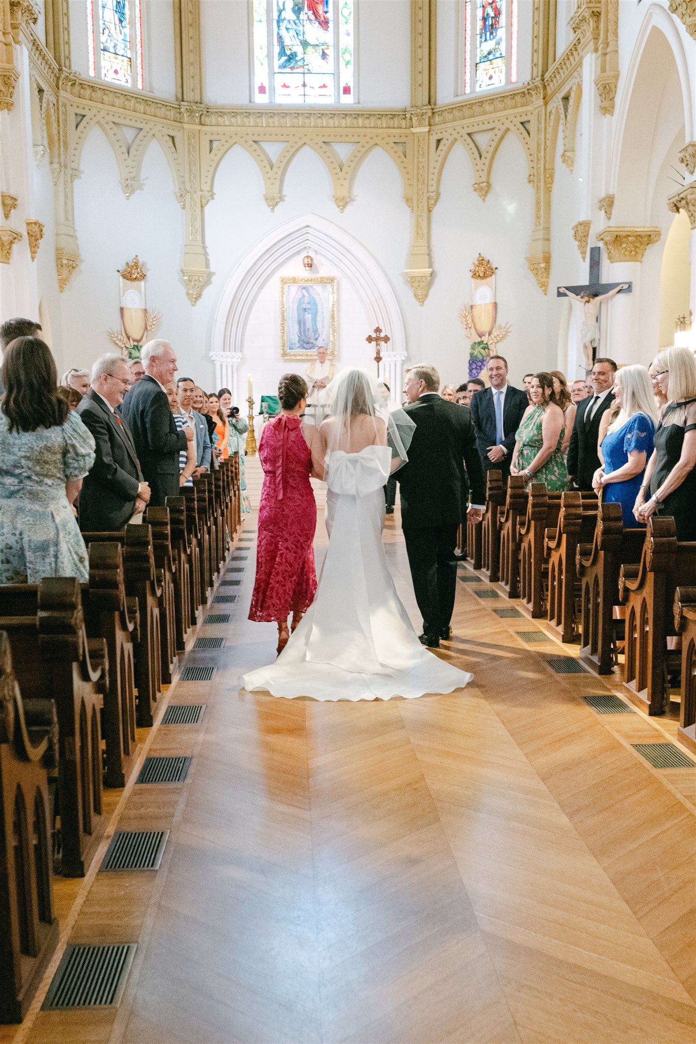 bride walking down the aisle with her mom and dada