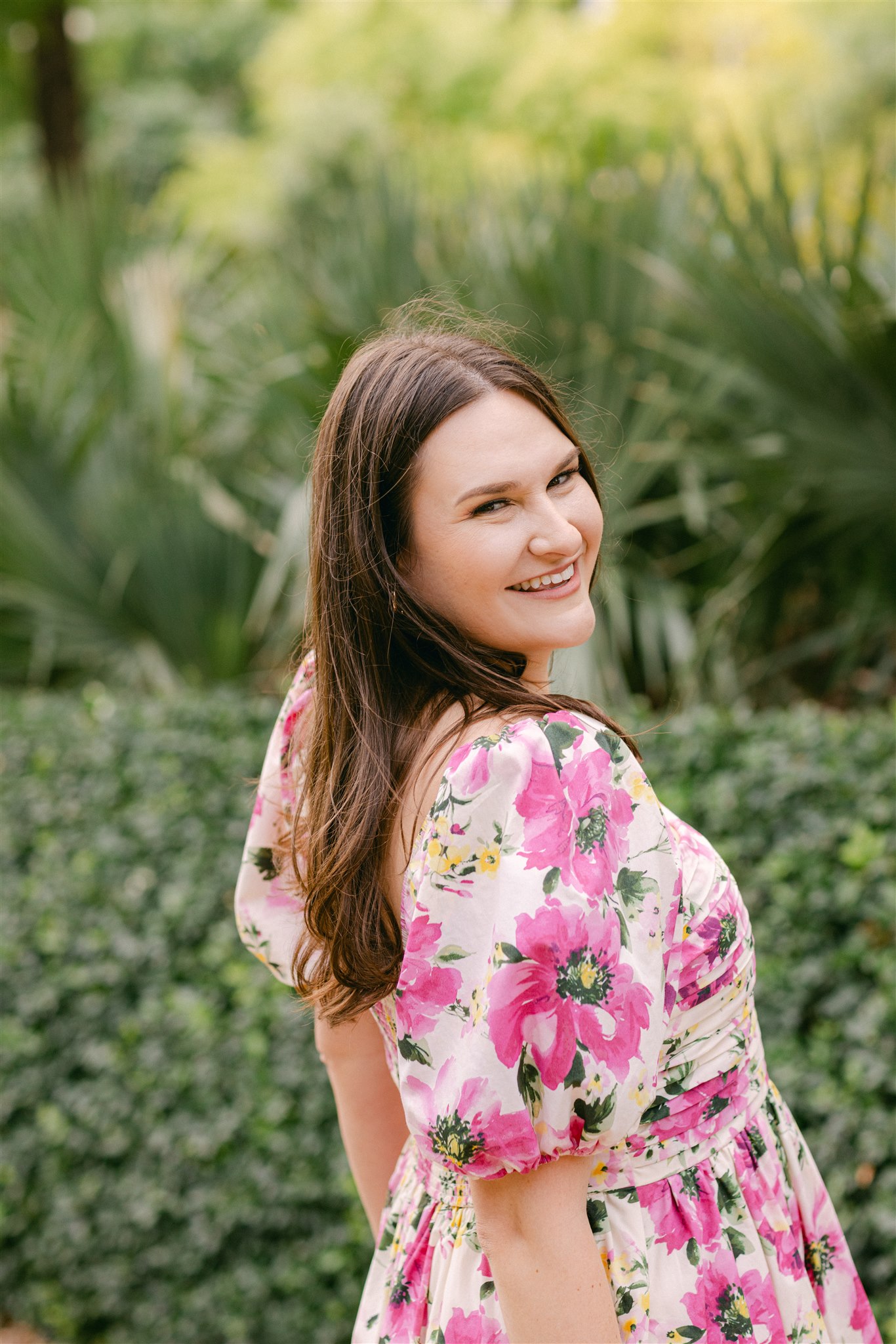 a girl wearing a pink floral dress during her engagement photos in dallas