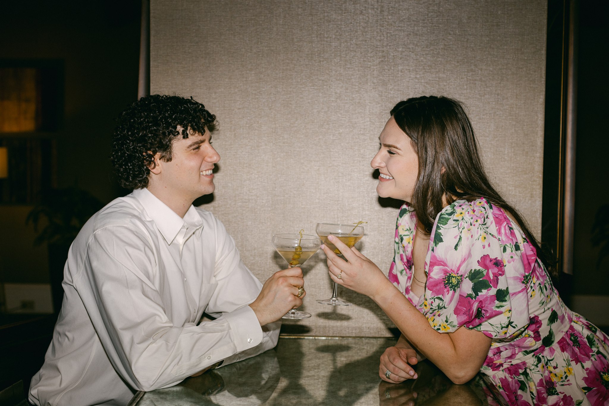 A couple drinking martini's during their engagement session in downtown dallas