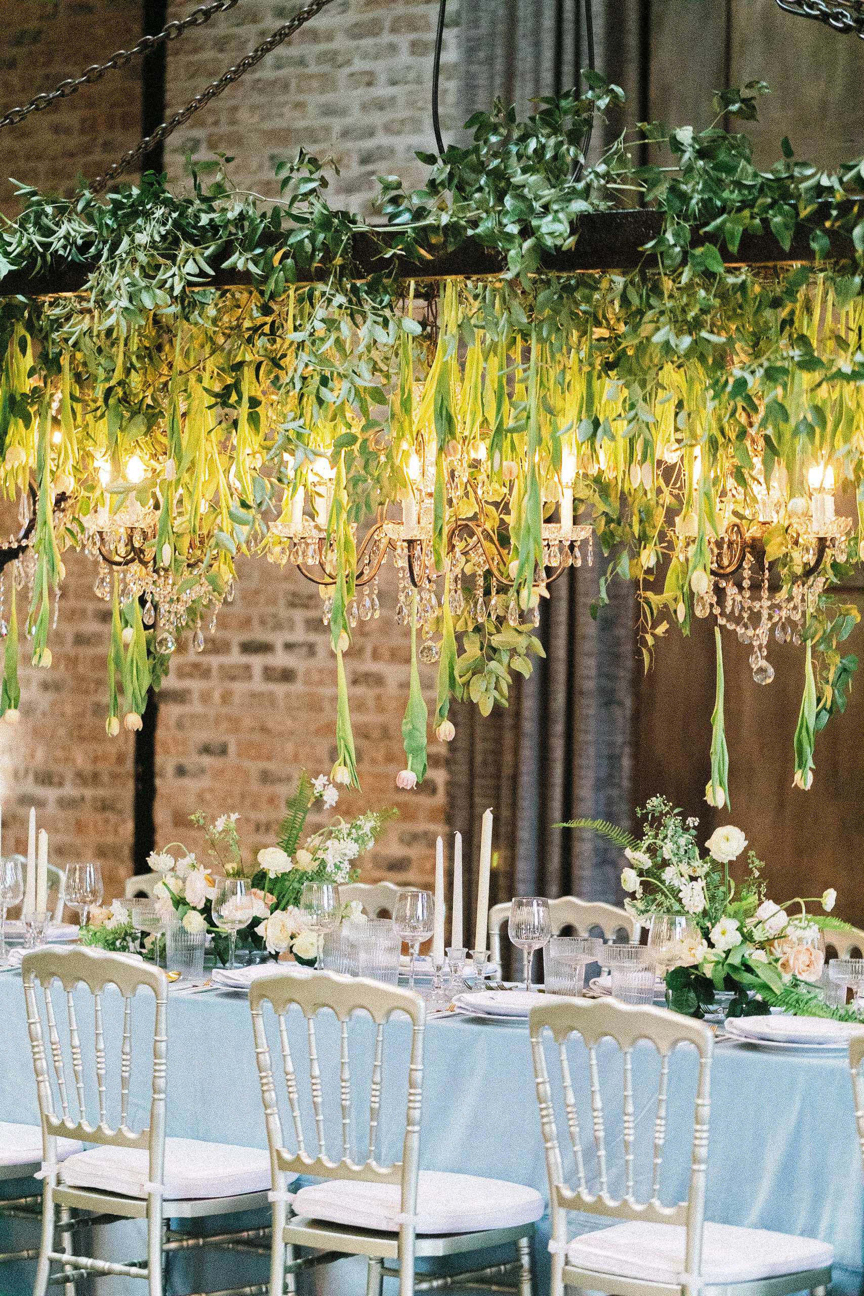 Wedding reception table with tulips hanging from the ceiling