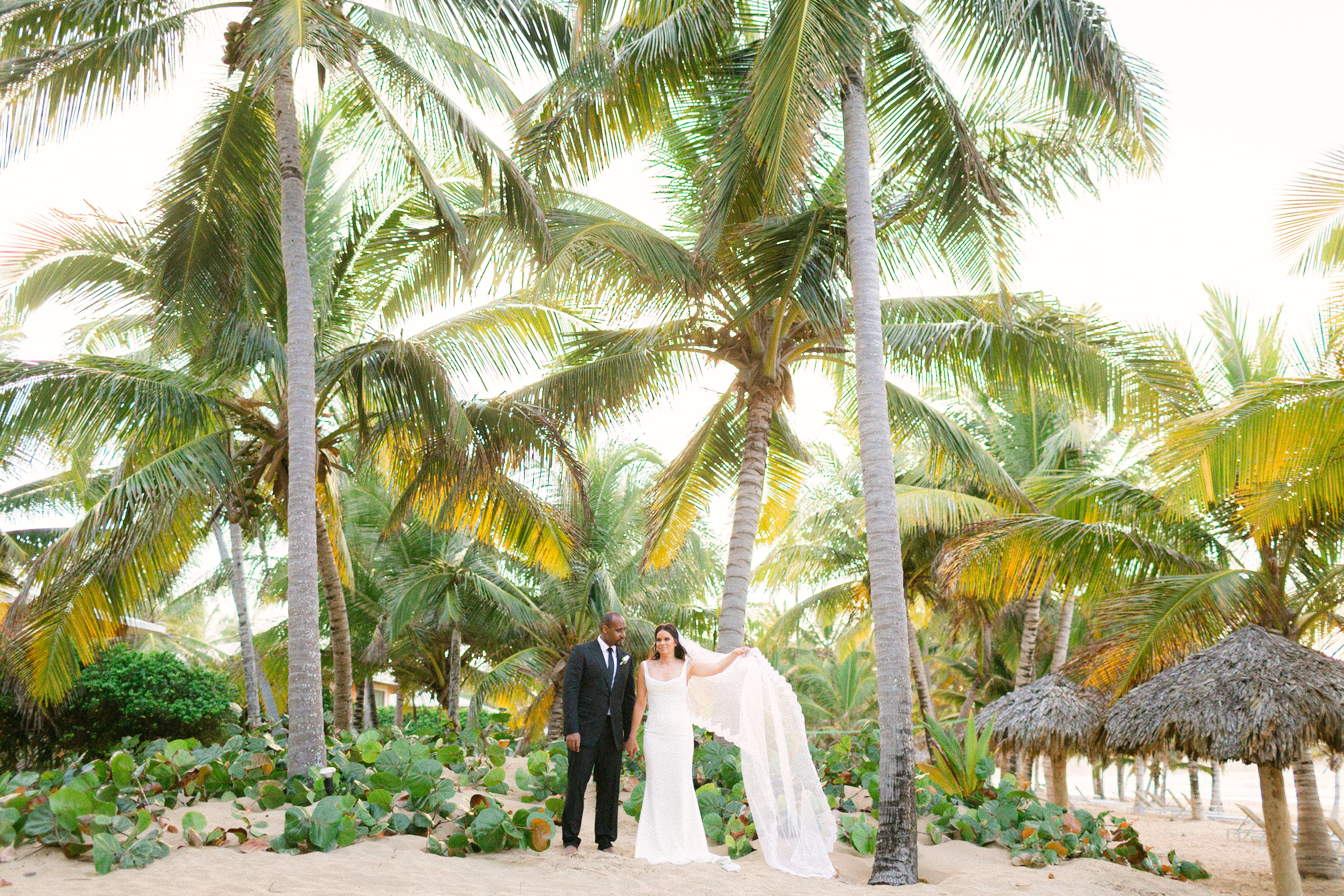 A destination wedding at the beach with the bride and groom in traditional wedding attire