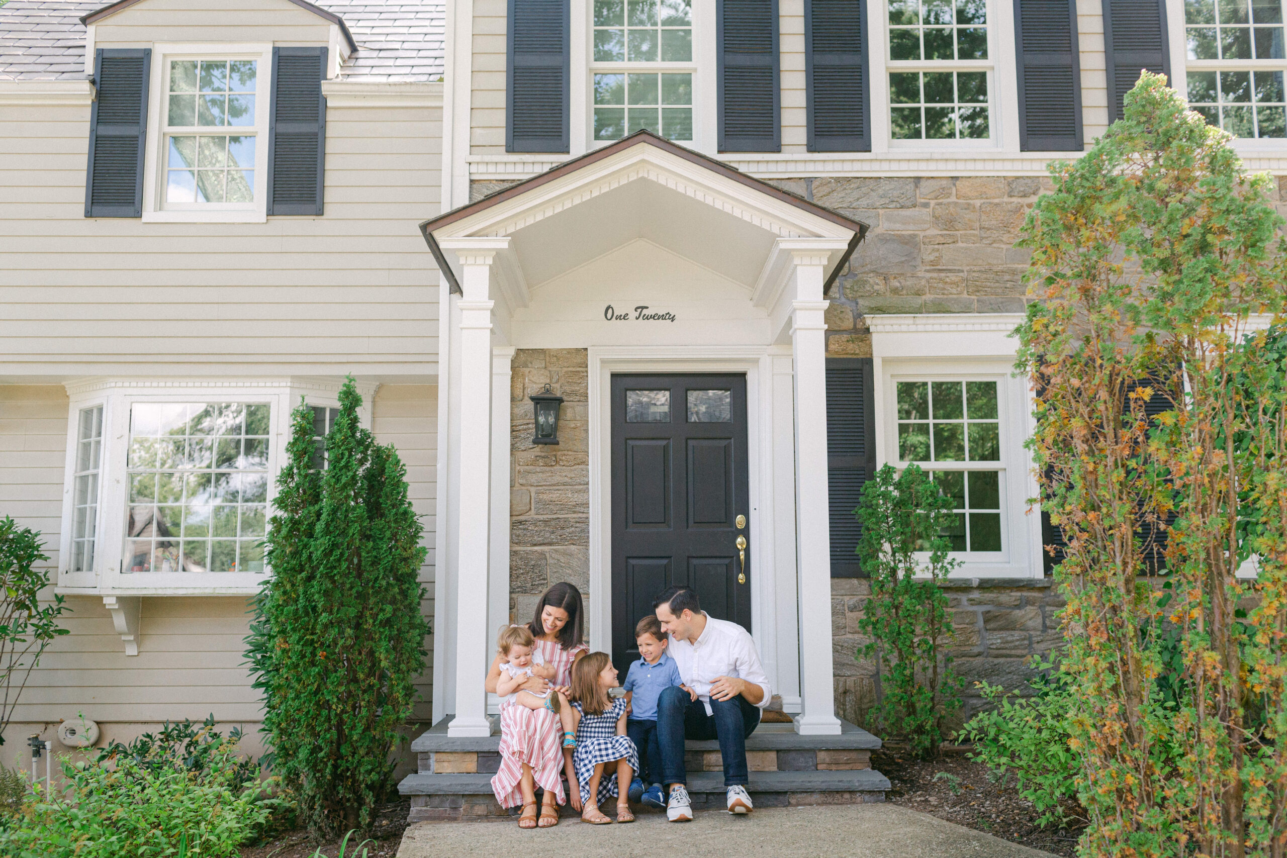 A family sitting on their front porch taking photos