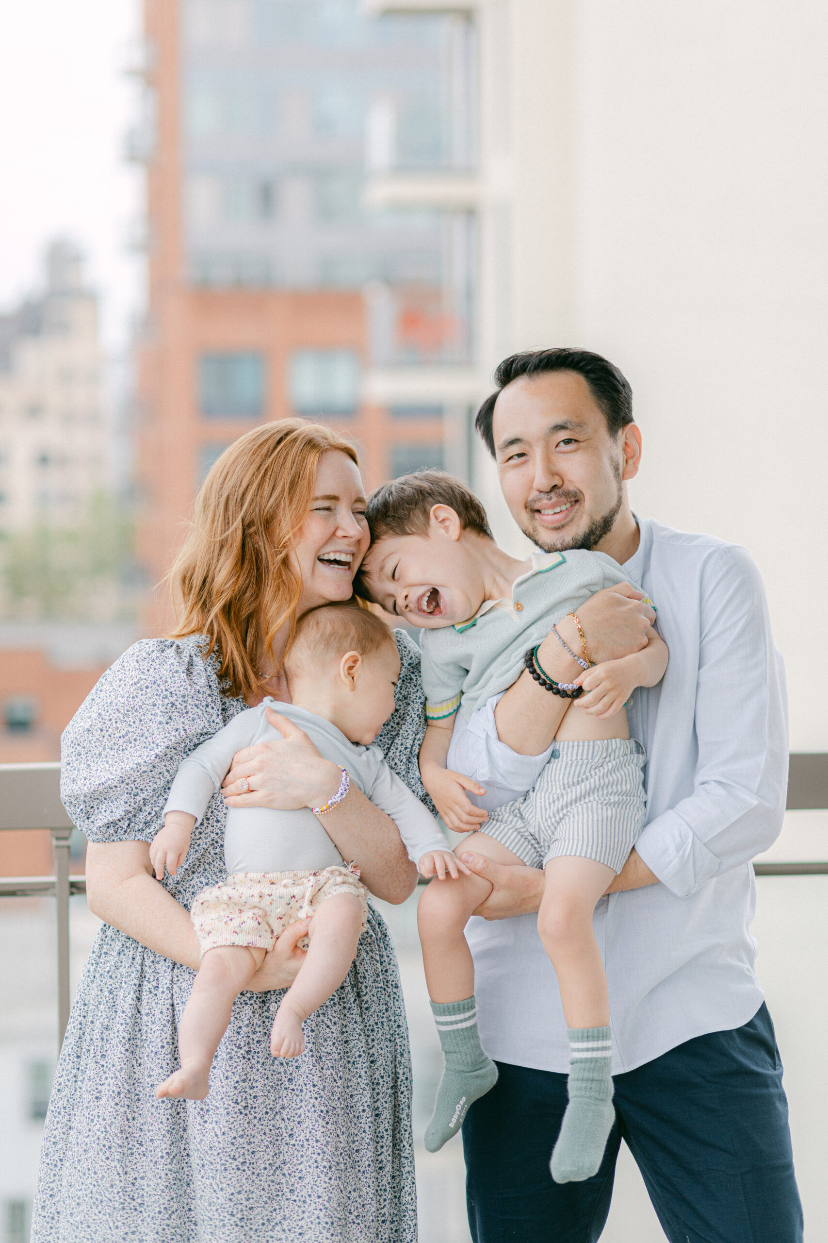 a husband and wife holding their two sons during family photos