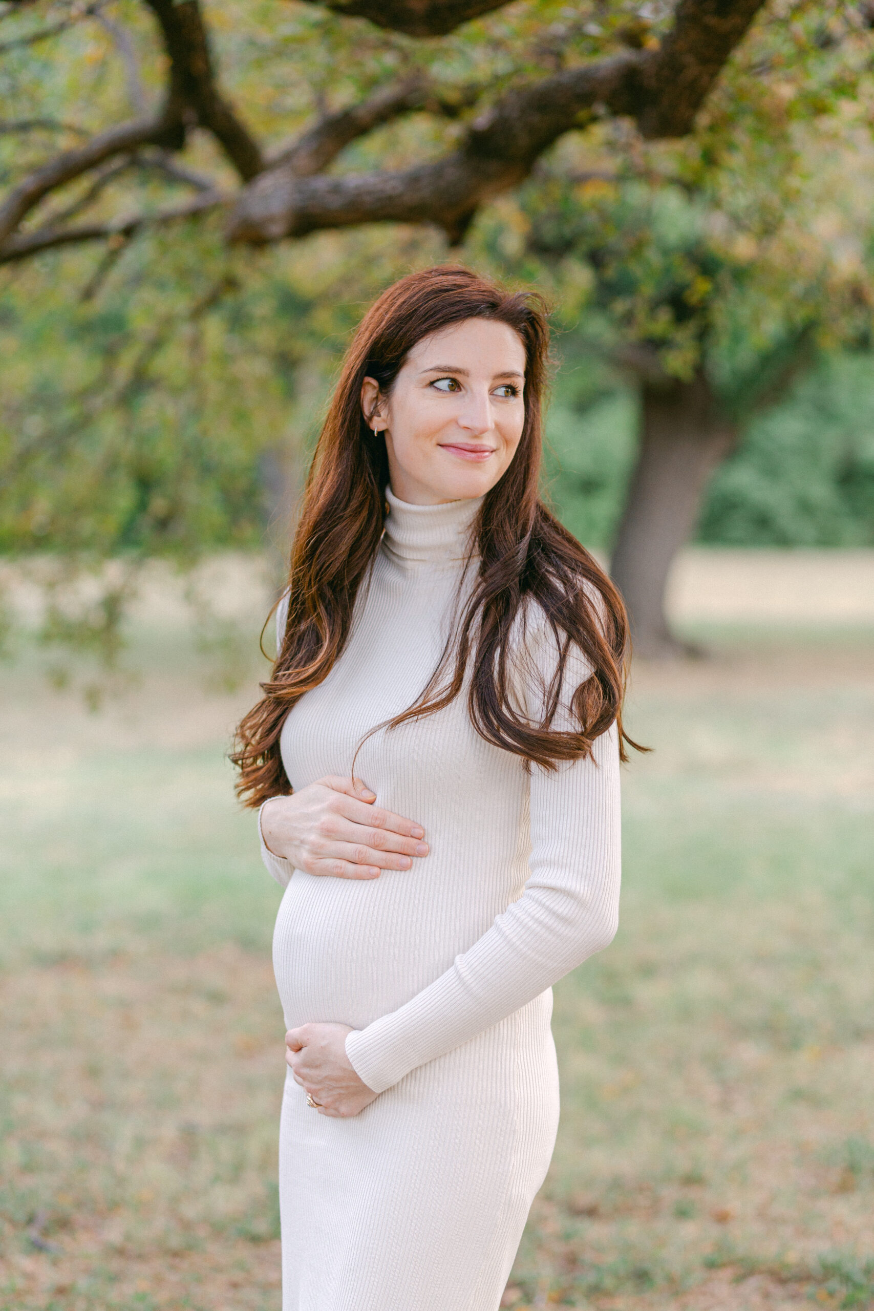 a mother to be holding her baby bump during her maternity photos