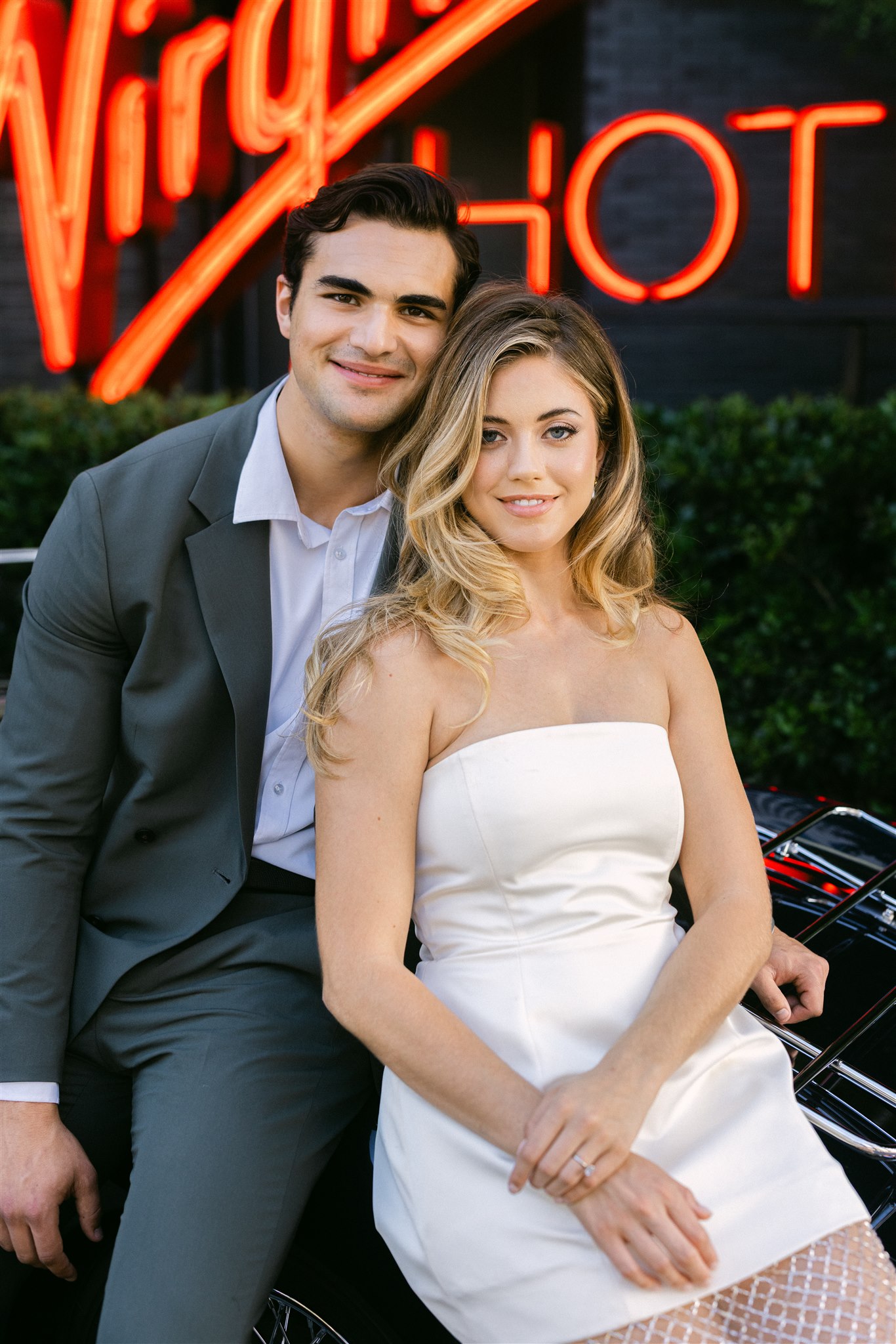 Rehearsal dinner at Virgin Hotels Dallas a couple leans against their vintage getaway car
