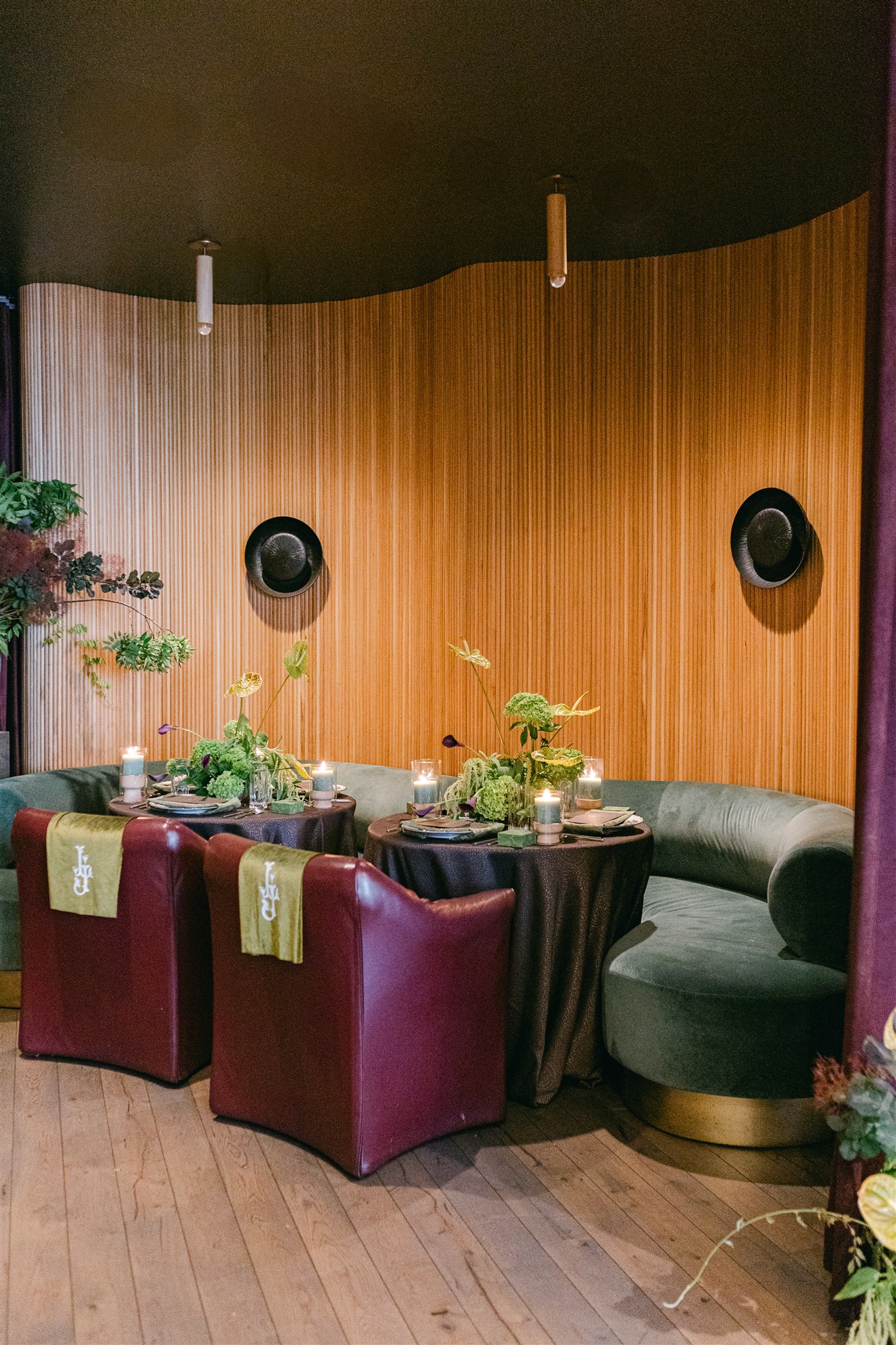 A moody rehearsal dinner at virgin hotels dallas with red chairs, lush green florals and gucci accents