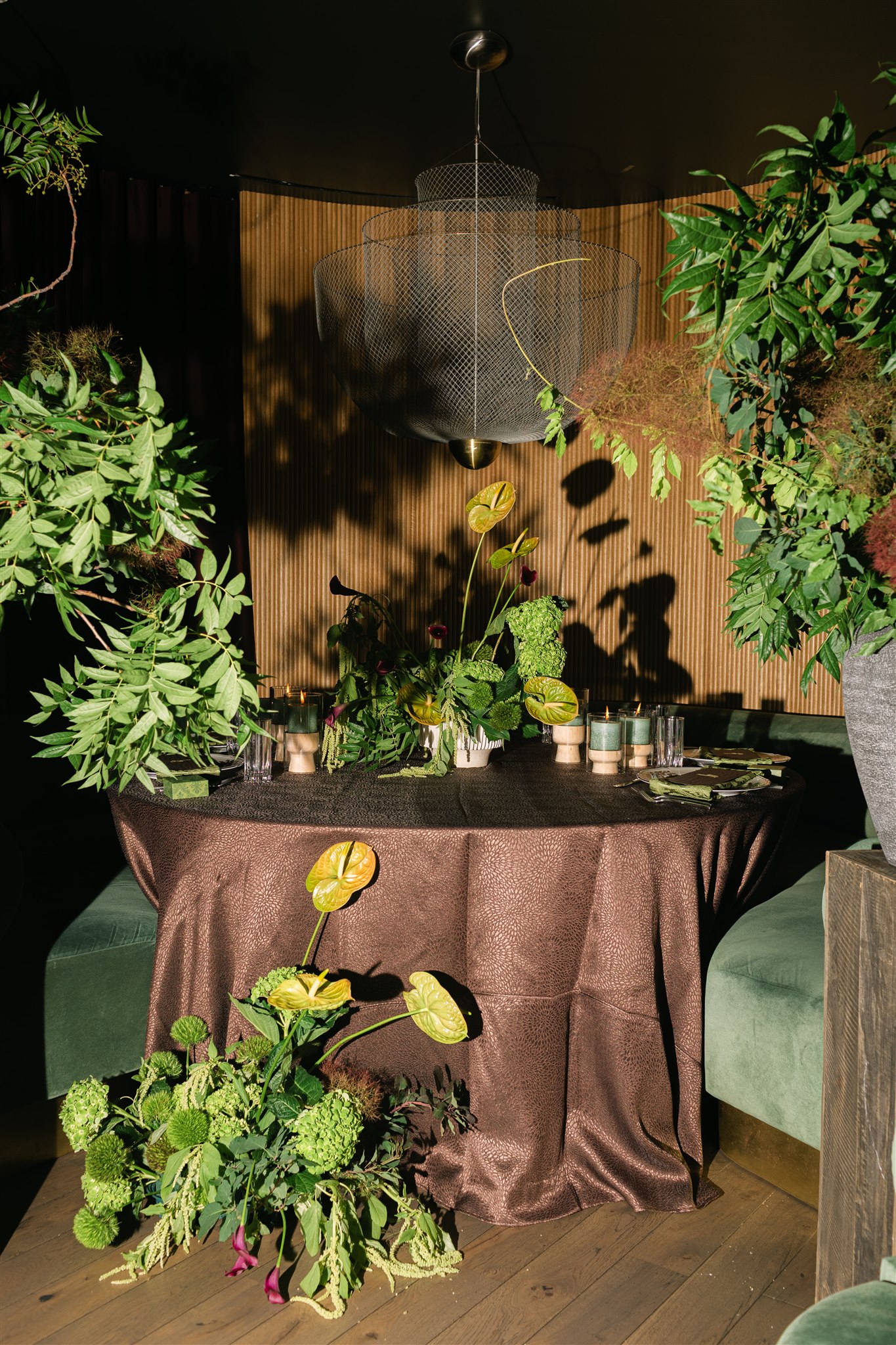 A moody rehearsal dinner at virgin hotels dallas with red chairs, lush green florals and gucci accents
