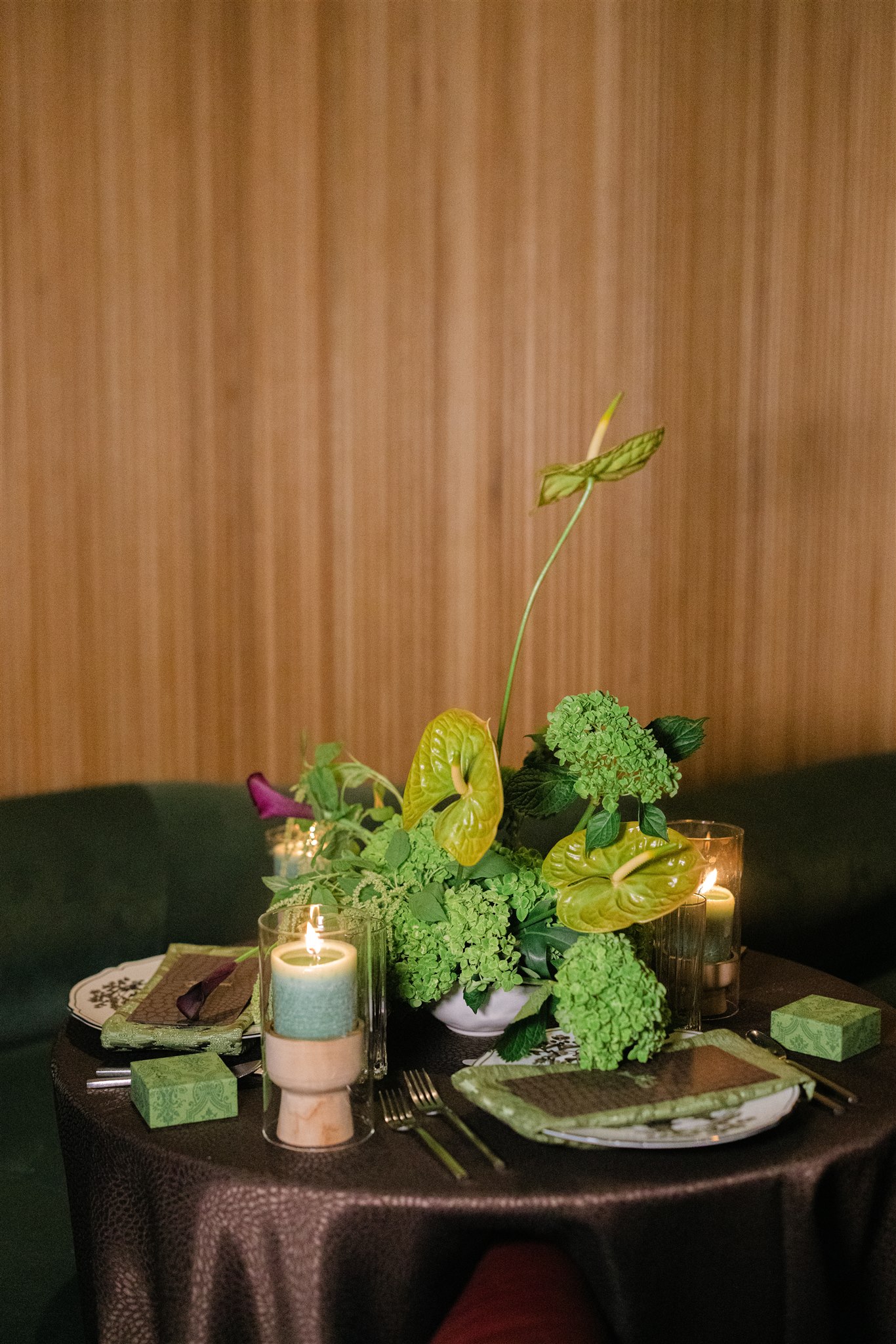 A moody rehearsal dinner at virgin hotels dallas with red chairs, lush green florals and gucci accents