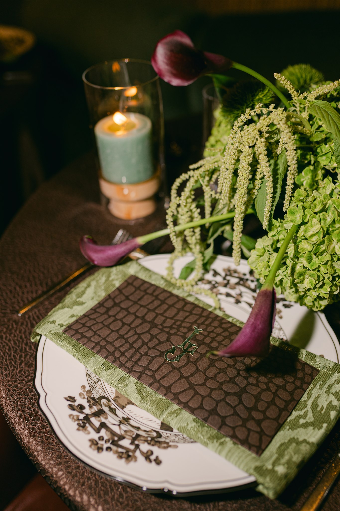 A moody rehearsal dinner at virgin hotels dallas with red chairs, lush green florals and gucci accents