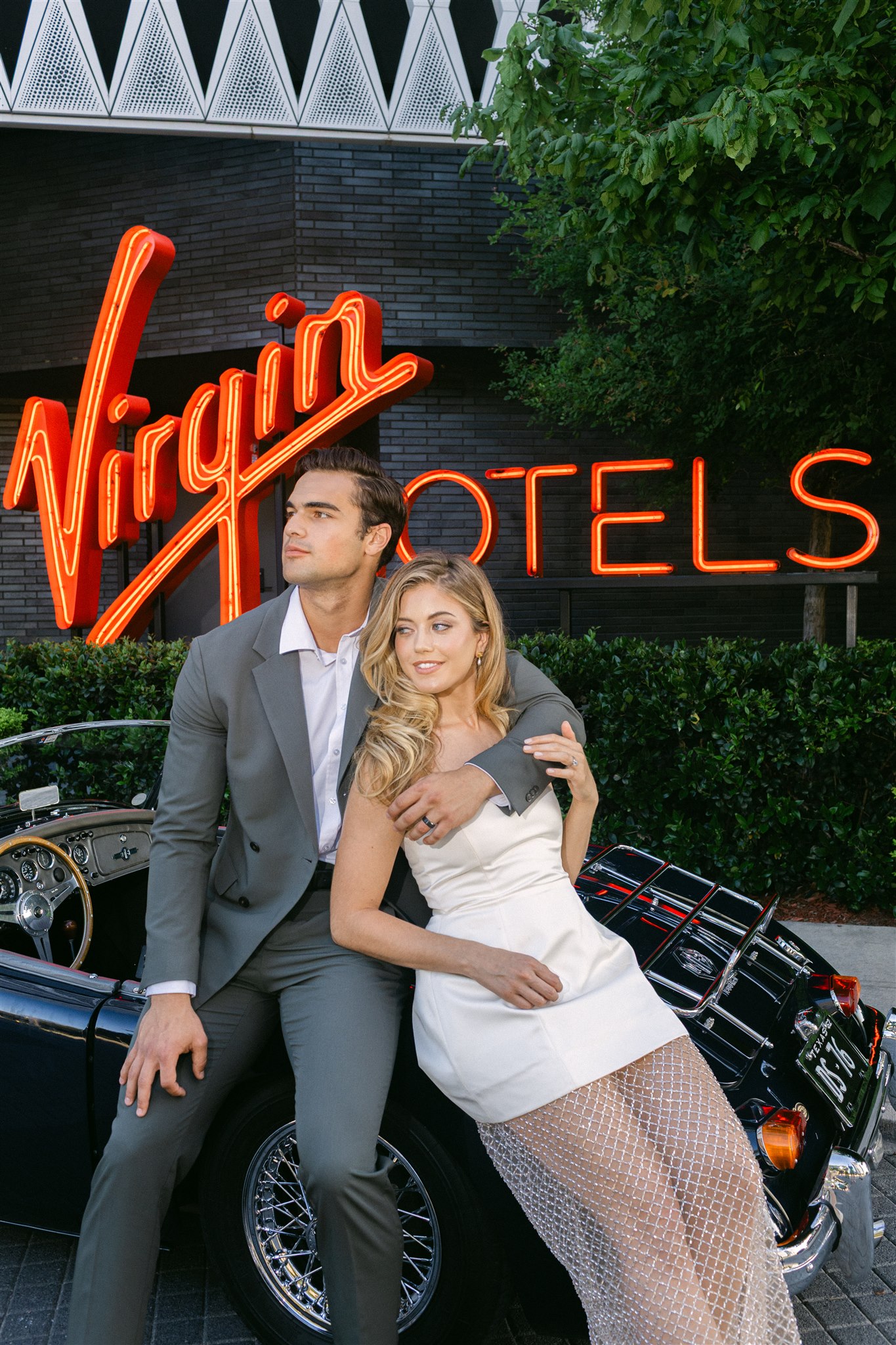 Rehearsal dinner at Virgin Hotels Dallas a couple leans against their vintage getaway car