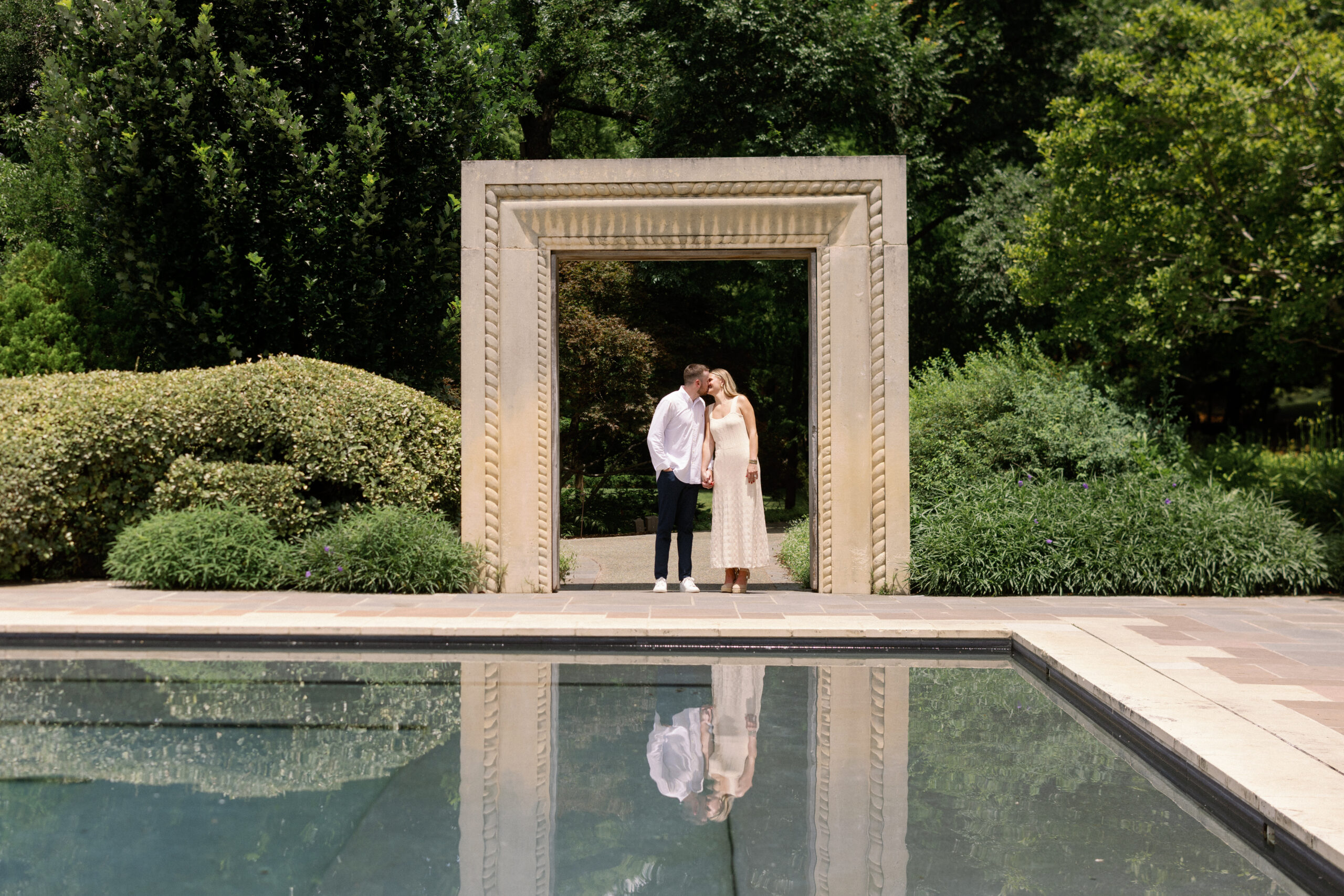 A man and a woman standing in an arch at the dallas arboretum