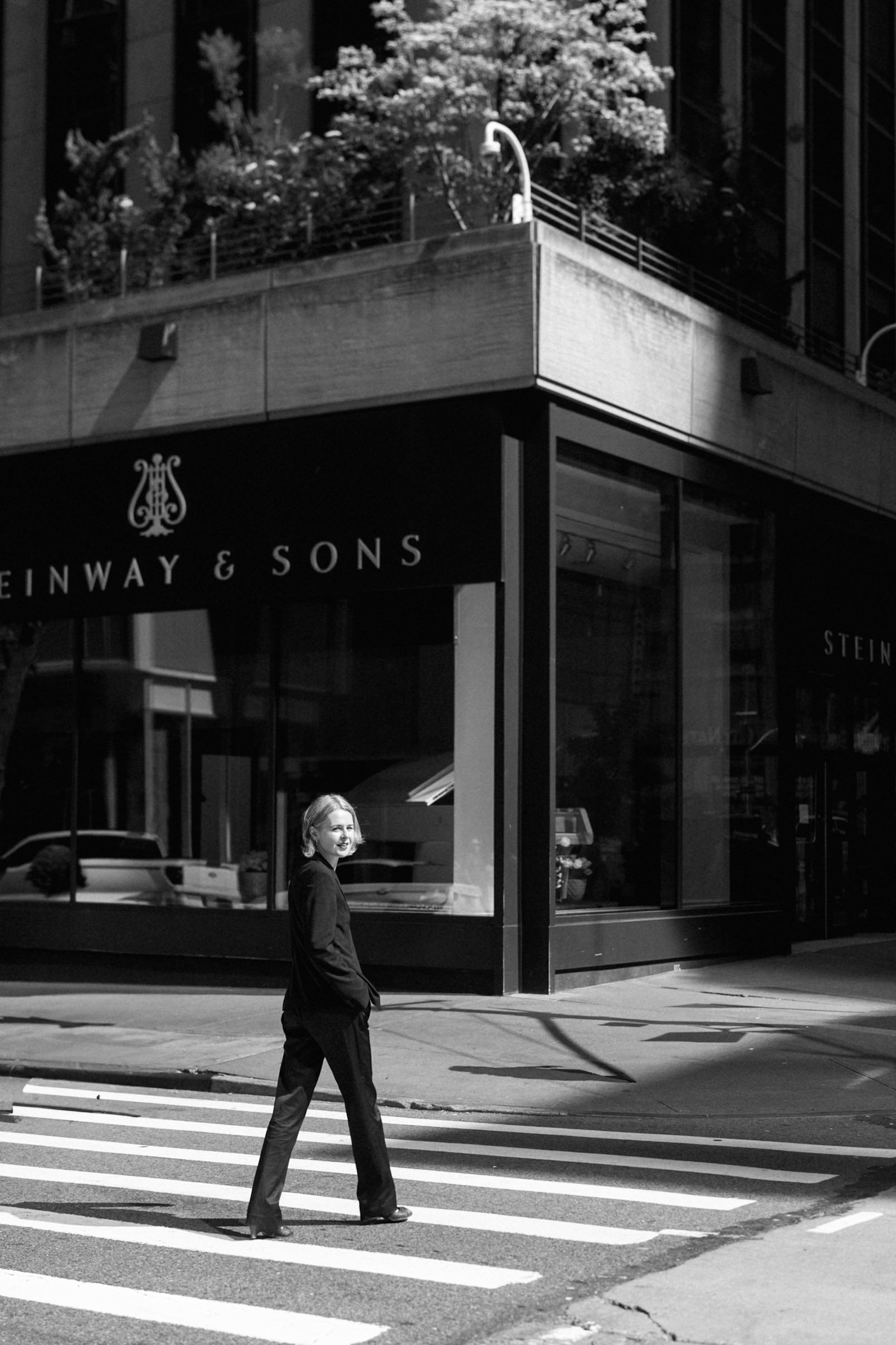 a woman in a suit walking across the street in NYC