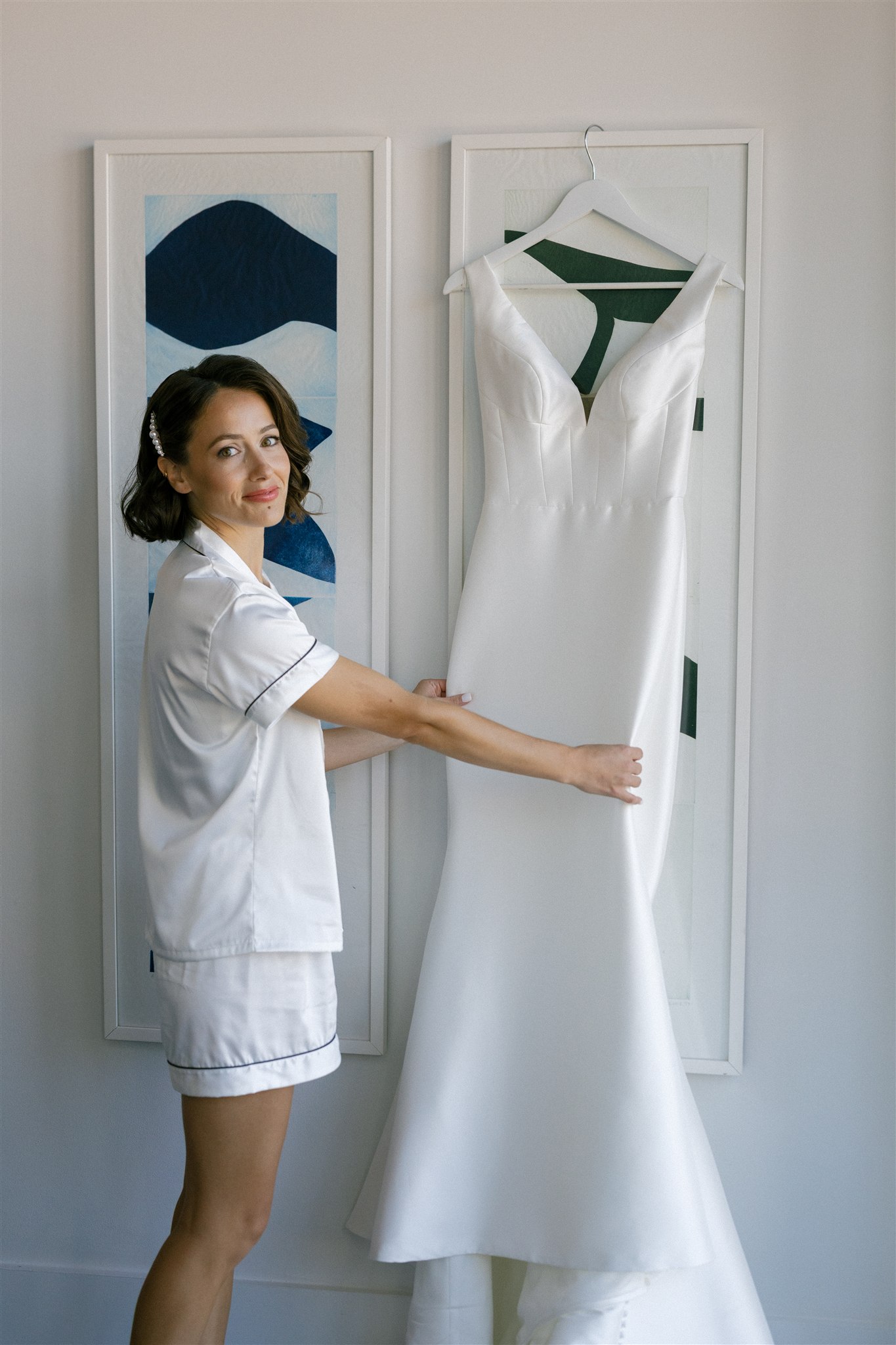 a bride holding her wedding dress before putting it on