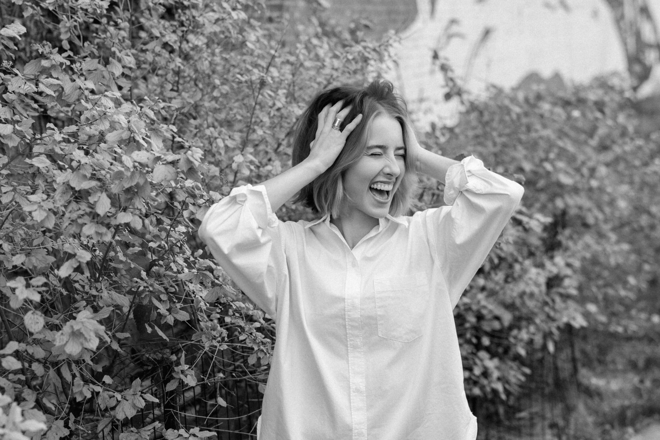 a girl wearing a white button down laughing