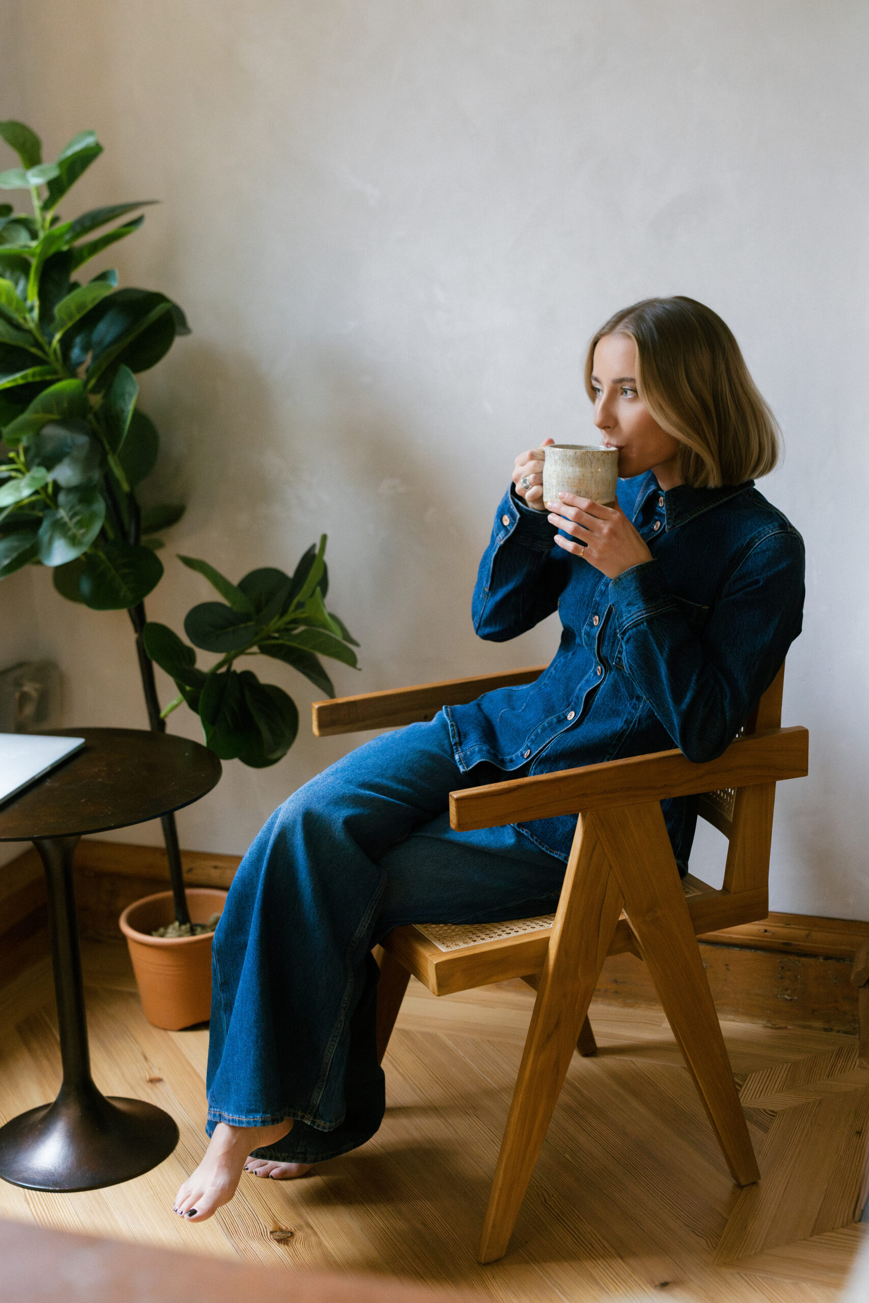 a nutritionist wearing an all denim outfit for her brand photos in NYC drinking tea