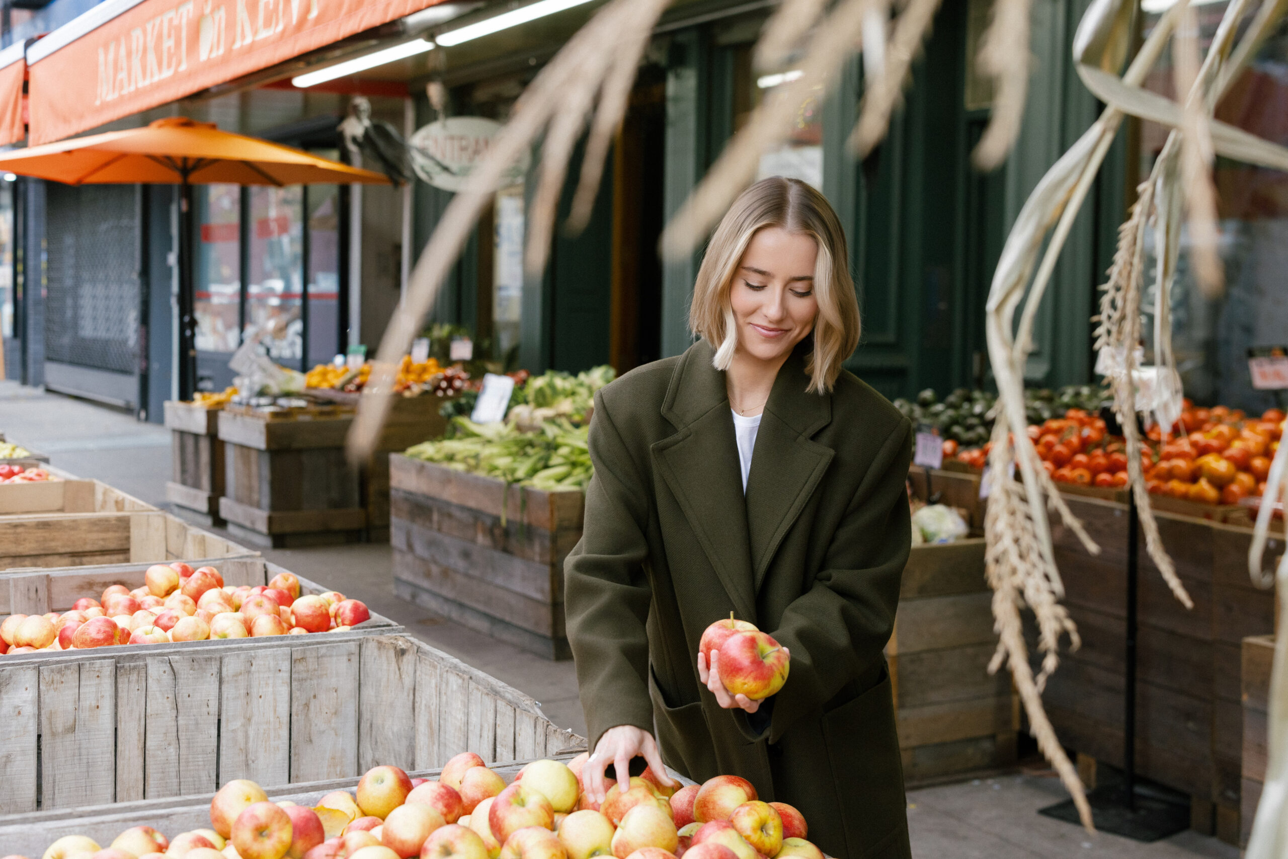 a girl outside picking out apples