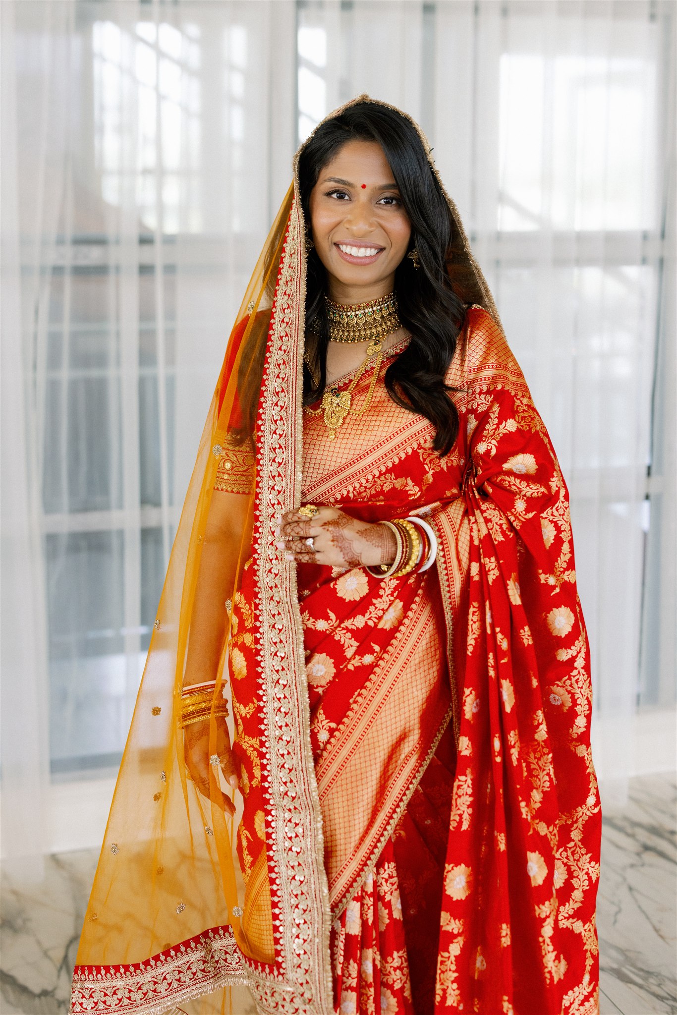 An Indian bride wearing a red lengha