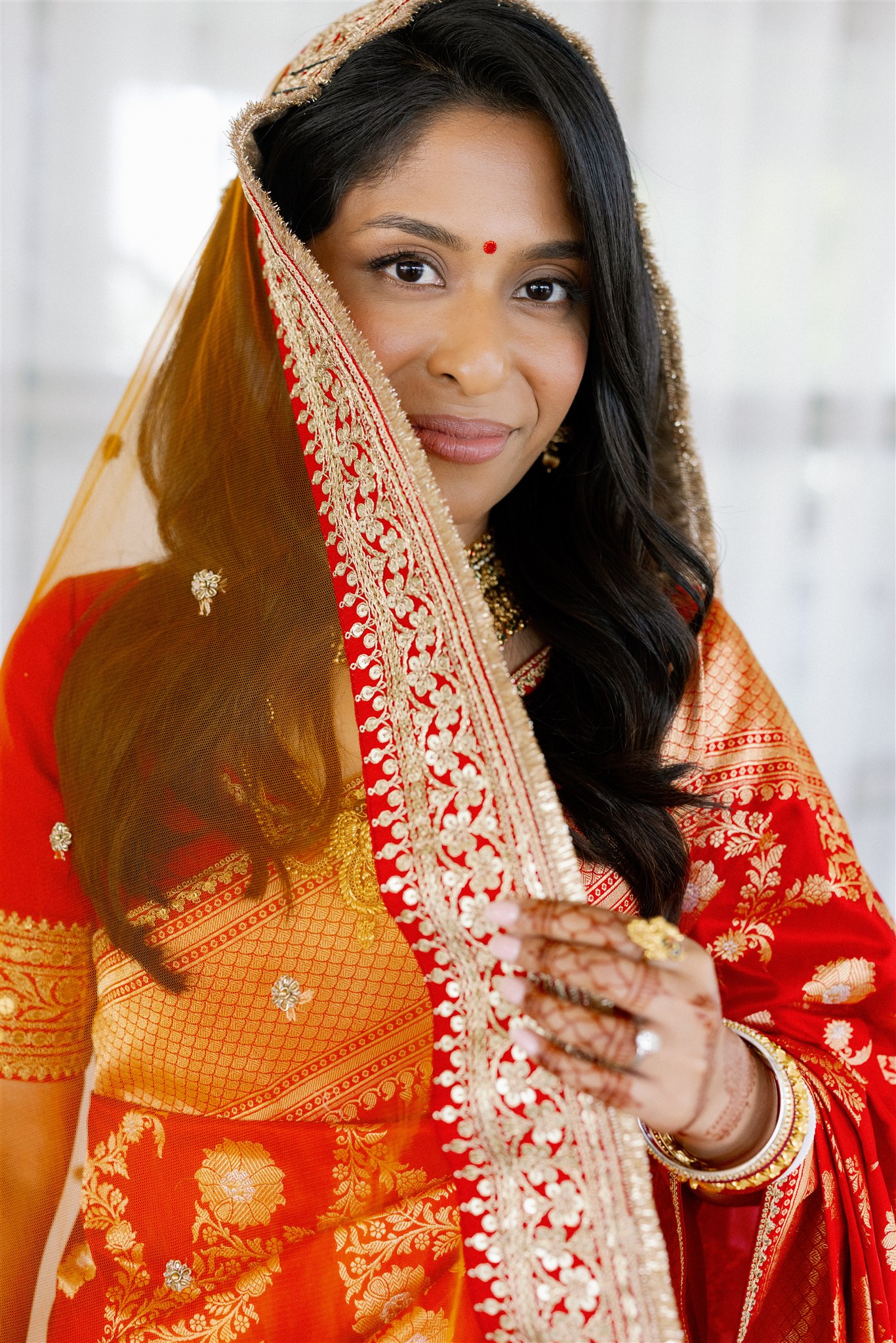 An Indian bride wearing a red lengha