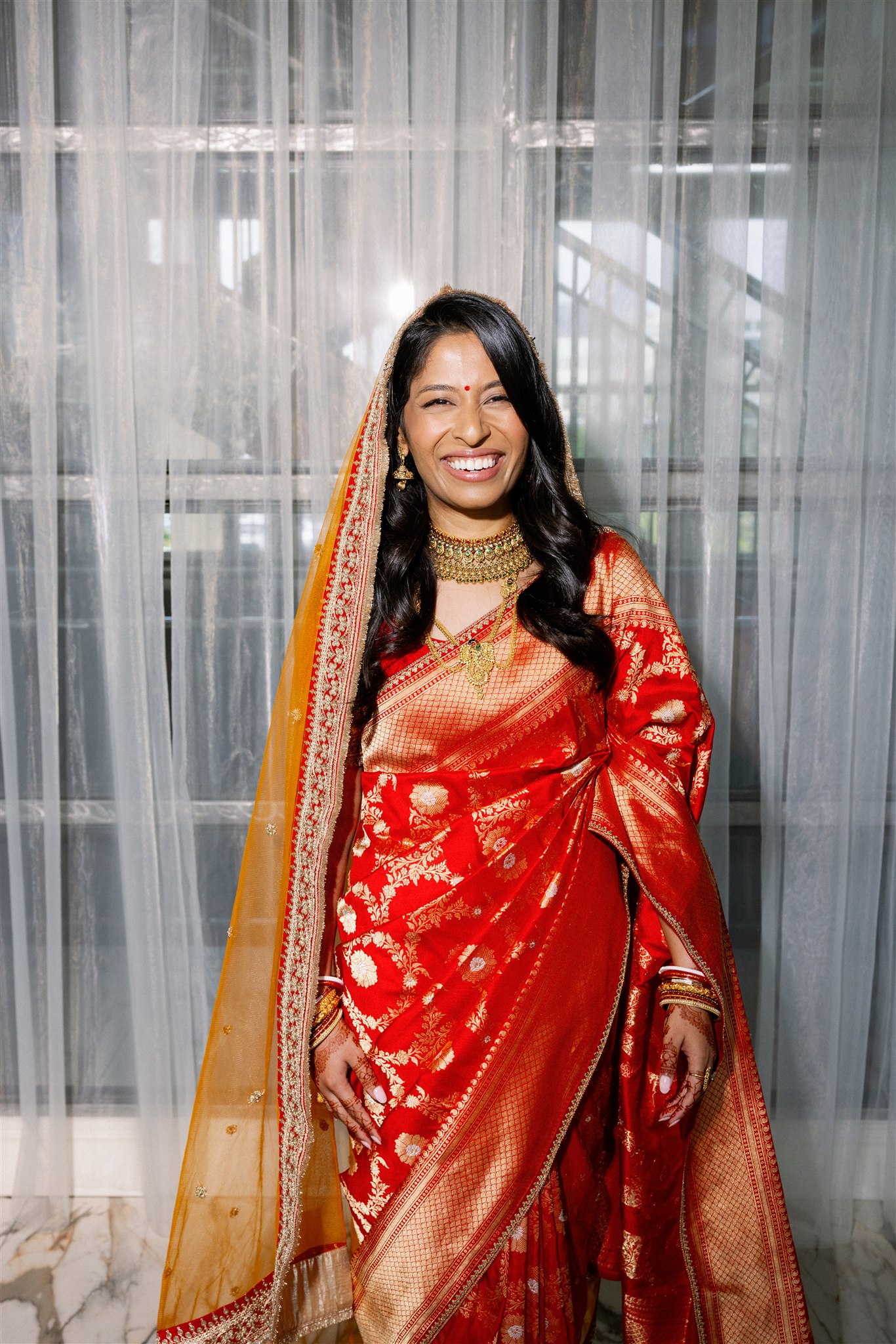 An Indian bride wearing a red lengha